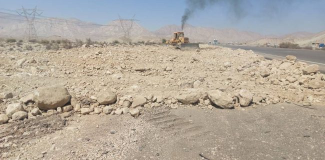 تسطیح شانه راه و پخش مصالح آسفالتی در محدوده روستای آبماه محور بندرعباس – حاجی‌آباد